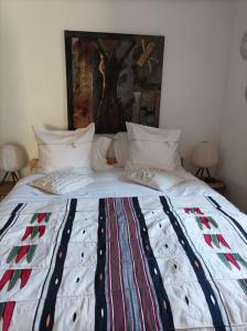Una cama con un edredón encima. en Chaumière avec sa toiture recouverte de chaume !!!, en Donnemain-Saint-Mamès