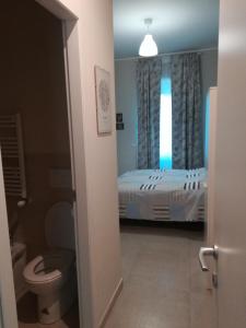 uma casa de banho com uma cama, um WC e uma janela em A casa da Cri B&B em Roma