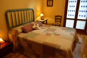 ein Schlafzimmer mit einem Bett mit einer Decke darauf in der Unterkunft Apartamento Batan in Huesca