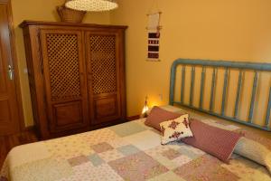 ウエスカにあるApartamento Batanのベッドルーム1室(ベッド1台付)、木製キャビネットが備わります。