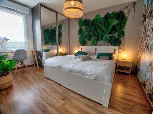 sypialnia z białym łóżkiem i dużym malowidłem roślinnym w obiekcie ☆ L'Exotique ☆ 2 chambres ☆ NETFLIX ☆ w Metz
