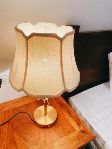een lamp op een tafel naast een bed bij Opera Premier Hotel in Luang Prabang