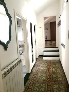 um corredor com paredes brancas e um piso com um tapete em Casa Gaia em Albissola Marina