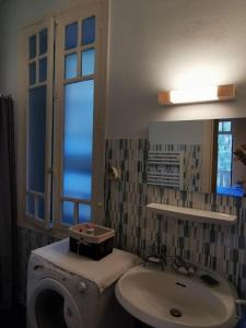 een badkamer met een wastafel, een toilet en een raam bij Studio avec balcon vue sur le Tech in Amélie-les-Bains-Palalda
