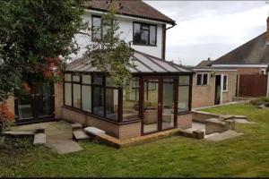 a house with a conservatory on the lawn at Mickleover House-Large Detatched Family House in Derby