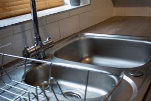 a stainless steel kitchen sink with a faucet at Mickleover House-Large Detatched Family House in Derby