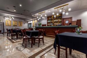 Hotel Poniatowski في رادوم: مطعم بطاولات وكراسي وبار
