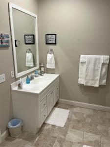 een badkamer met een wastafel, een spiegel en handdoeken bij Stay at Rivermist Dahlonega in Dahlonega