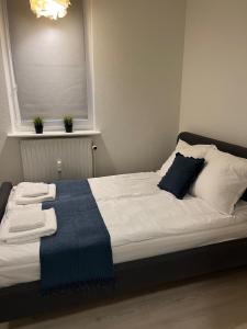 a bed with a blue blanket on top of it at Lille Vedelsborg in Vejle