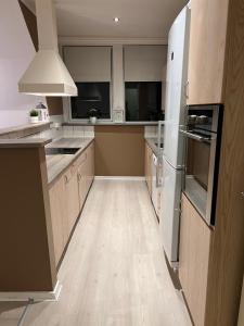 a large kitchen with white appliances and wooden cabinets at Lille Vedelsborg in Vejle +4 photos