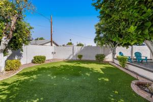 une cour avec une clôture et une pelouse verte dans l'établissement Modern Desert, à Tempe