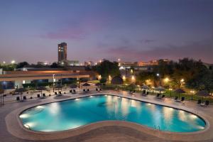 a large pool with chairs and umbrellas at night at InterContinental Riyadh, an IHG Hotel in Riyadh