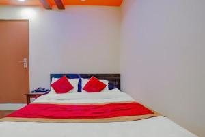 Un dormitorio con una cama con almohadas rojas. en Guru hotel and lodge, en Itahari