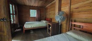 - une chambre avec 2 lits dans une cabane en bois dans l'établissement Cabaña Tu´ur, à Lacanjá