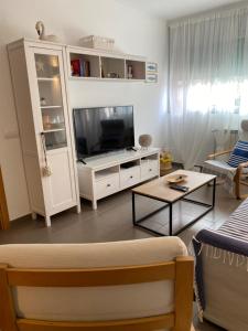 a living room with a tv and a couch at Fantastic apartment a few meters from the beach in the center of Estartit in L'Estartit