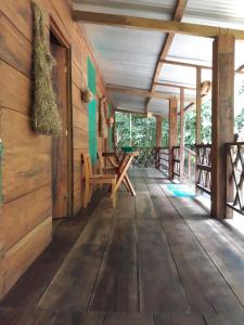 a wooden porch of a cabin with a table and benches at Cabaña Tu´ur in Lacanjá