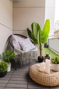uma varanda com uma mesa de vime e vasos de plantas em Flexible SelfCheckIns 36 - Zagreb - Garage - Loggia - New - Luxury em Zagreb