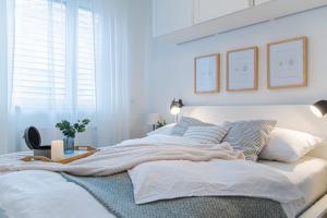 biała sypialnia z dużym łóżkiem z poduszkami w obiekcie Flexible SelfCheckIns 36 - Zagreb - Garage - Loggia - New - Luxury w Zagrzebiu