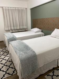 1 dormitorio con 2 camas y ventana en Ap lindo, moderno, confortável, novo!, en Cumbuco