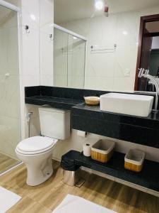 a bathroom with a white toilet and a sink at Ap lindo, moderno, confortável, novo! in Cumbuco