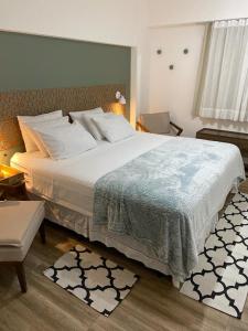 1 dormitorio con 1 cama grande con colcha blanca en Ap lindo, moderno, confortável, novo!, en Cumbuco