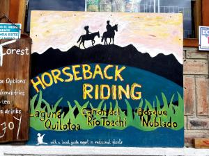 a sign for horseback riding on the side of a building at Hostal Cloud Forest in Chugchilán