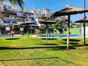 een park met parasols en een zwembad bij Sanlúcar Playa de las Piletas in Sanlúcar de Barrameda