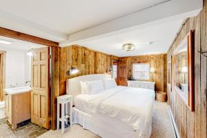 a bedroom with wooden walls and a bed and a sink at Chalet at the Base of Okemo Mountain in Ludlow