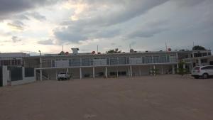 a large building with cars parked in front of it at Apartamentos Mundo Maya Habitaciones in Flores