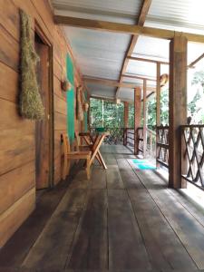 eine Veranda einer Holzhütte mit einer Holzbank in der Unterkunft Cabaña Tu´ur in Lacanjá