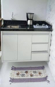 a kitchen with a sink and a counter top at Suítes Viver Bahia Morro Sao Paulo in Morro de São Paulo