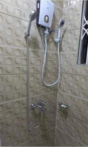 La salle de bains est pourvue d'une douche avec un pommeau de douche. dans l'établissement BAFFOUR STUDIO, à Kumasi