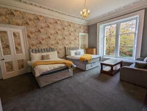 a bedroom with two beds and a couch at Bonnyside House in Bonnybridge