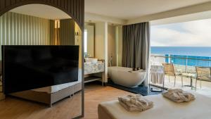 ein Hotelzimmer mit einer Badewanne und einem großen TV in der Unterkunft Alarcha Hotels & Resort - Ultra All Inc in Manavgat