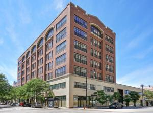 un grand bâtiment en briques dans une rue avec des voitures garées devant dans l'établissement Spacious and Luxurious 3br/2ba near McCormick Place with optional parking, à Chicago