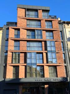a tall red brick building with a sign on it at Abrazo Sofia Hotel by HMG in Sofia