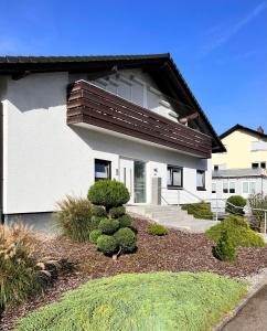 une maison avec une brousse devant elle dans l'établissement xxl Apartment Sinsheim, à Sinsheim
