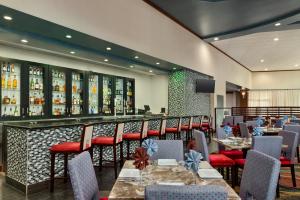 a restaurant with tables and chairs and a bar at Holiday Inn Louisville East - Hurstbourne by IHG in Louisville
