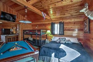 a log cabin bedroom with a bed and a pool table at Happy Heart Bunkhouse in Pinetop-Lakeside