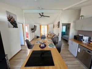 cocina y sala de estar con una larga mesa de madera en Diamant Noir, en Saint-Pierre