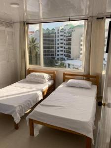 2 camas en una habitación con ventana grande en Lindo apartamento en el mejor sector de la isla. piscina, bbq, playa a 30 metros, en San Andrés