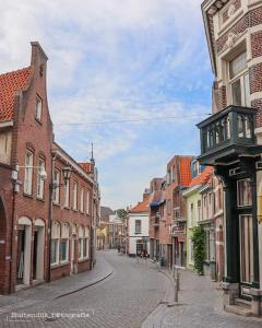 eine leere Straße in einer Altstadt mit Gebäuden in der Unterkunft studio ' aan de Nieuwstraat ' Sint Annaland in Sint-Annaland