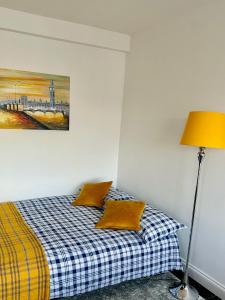 a bedroom with a bed with a lamp and a painting at Beautiful Quality Apartment in Camden Town in London