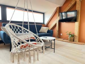 a hanging hammock in a living room with a couch at Chopin view - Apartament z widokiem in Toruń