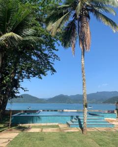 a swimming pool with a view of the water at BEIRA MAR - PRAIA Do LÁZARO in Ubatuba