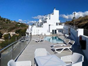 a balcony with white chairs and a swimming pool at Balcon del Mar Seaview 114 Casasol in Nerja