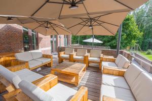 patio z krzesłami, stołami i parasolem w obiekcie Het Dorpshuys - vakantiewoning tot 12 personen w mieście Maaseik