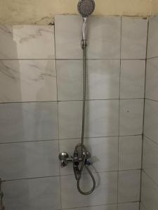 una doccia con soffione su una parete piastrellata di Vine suites a Kampala