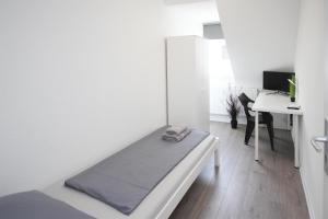 Dieses weiße Zimmer verfügt über ein Bett und einen Schreibtisch. in der Unterkunft ALFA 2 Zimmer Apartment Mitarbeiter Monteure nahe Daimler Küche Netflix INET WM in Stuttgart