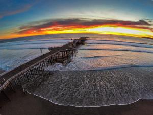 an aerial view of a pier on the beach at sunset at Holiday Inn Express Grover Beach-Pismo Beach Area by IHG in Grover Beach +46 photos